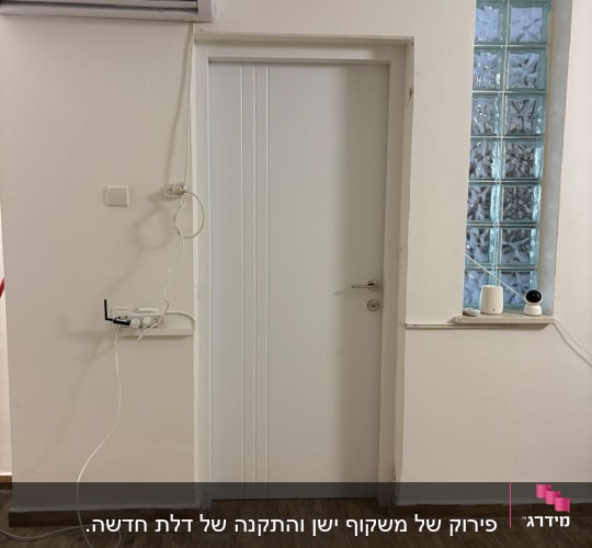 דלת לבנה עם רצפת עץ ומזגן על הקיר